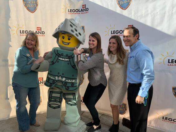 Workers pose with one of the Legoland characters