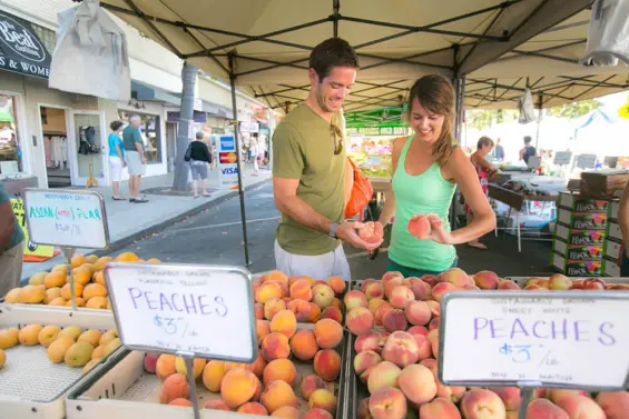 A couple purchases produce at a local farmers market in Carlsbad