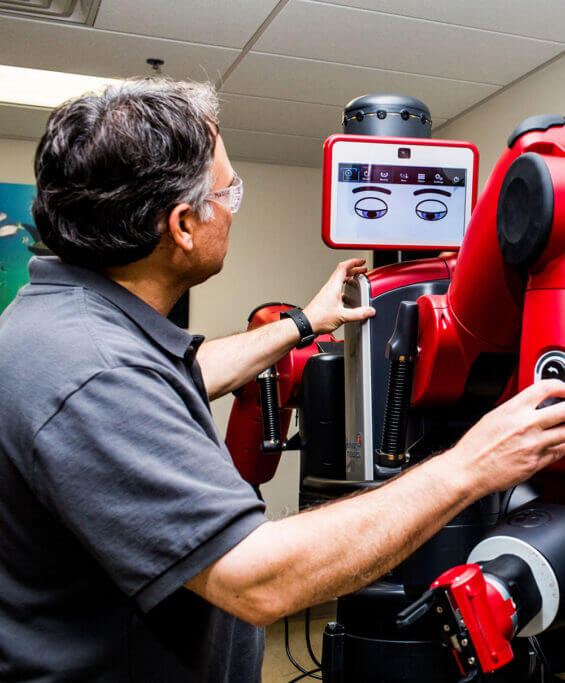 A man maneuvers the pieces of a large robotic arm